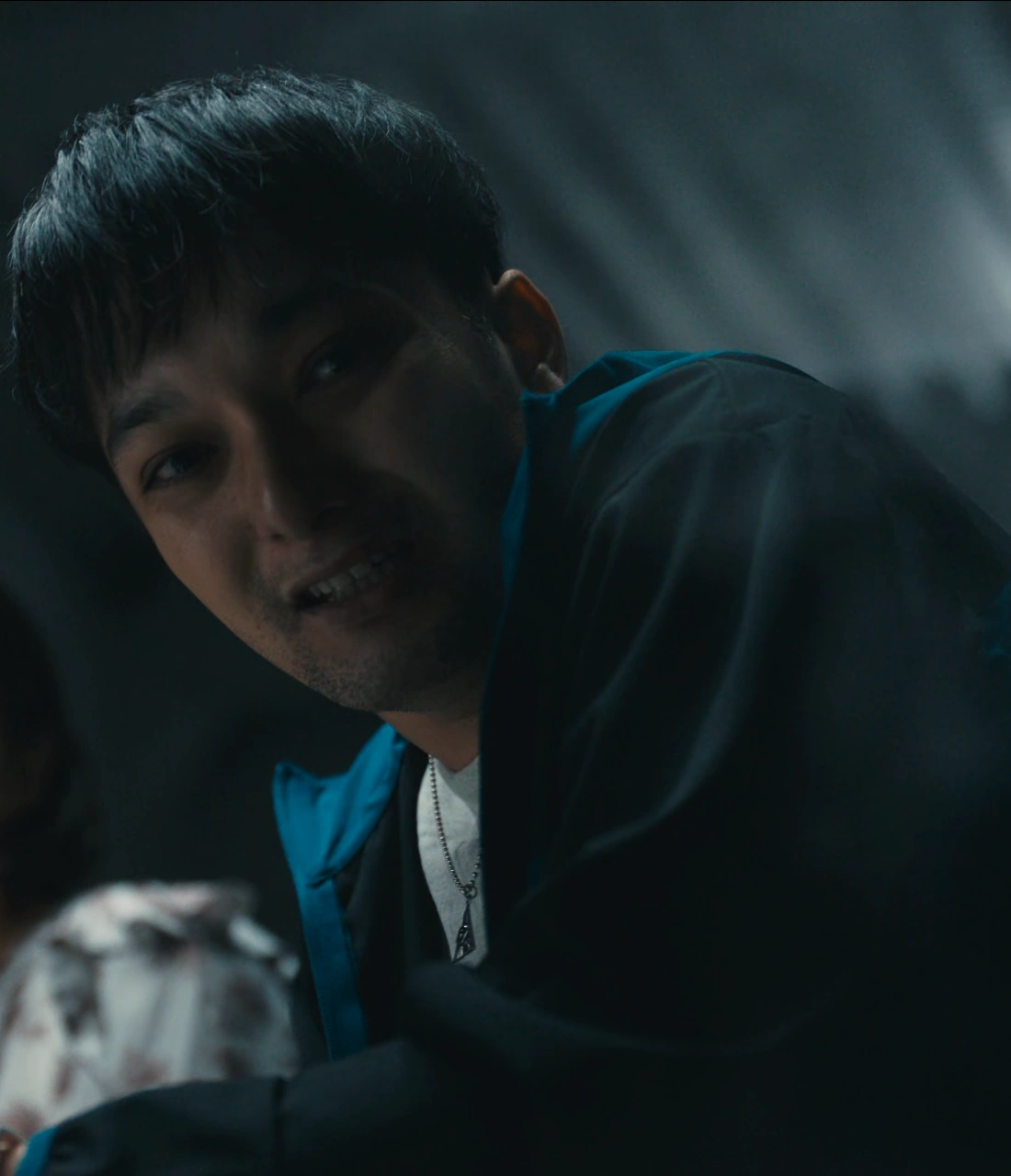 A screenshot of an unnamed player from Season 3, a middle-aged man with short black hair, wearing a blue jacket, looking down with a terrified expression