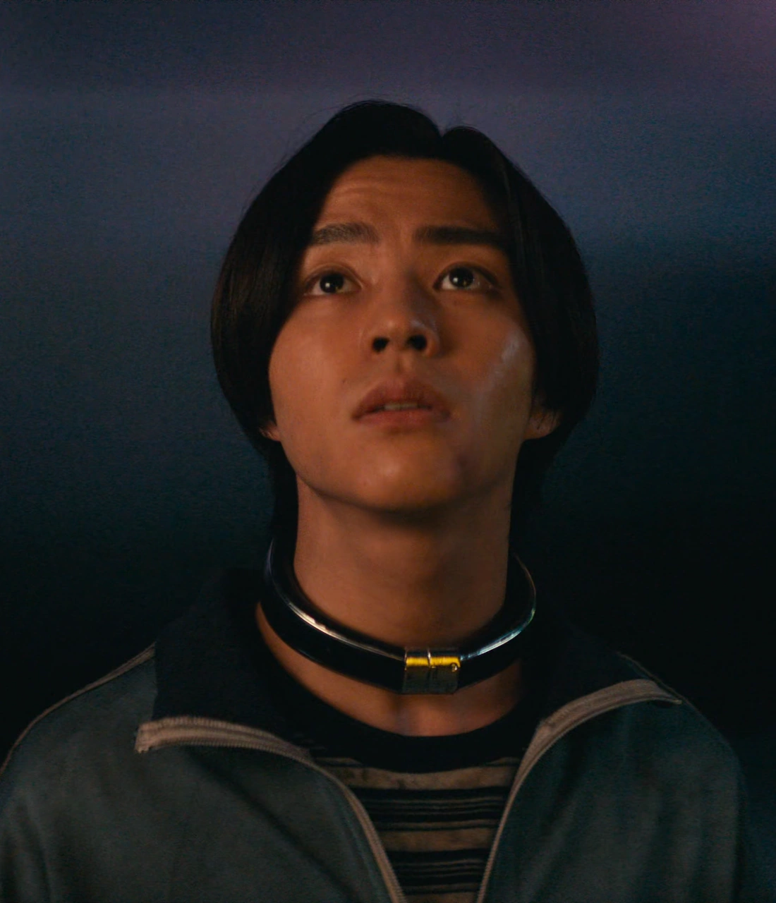A close-up shot of Nobu looking upwards with a tense expression