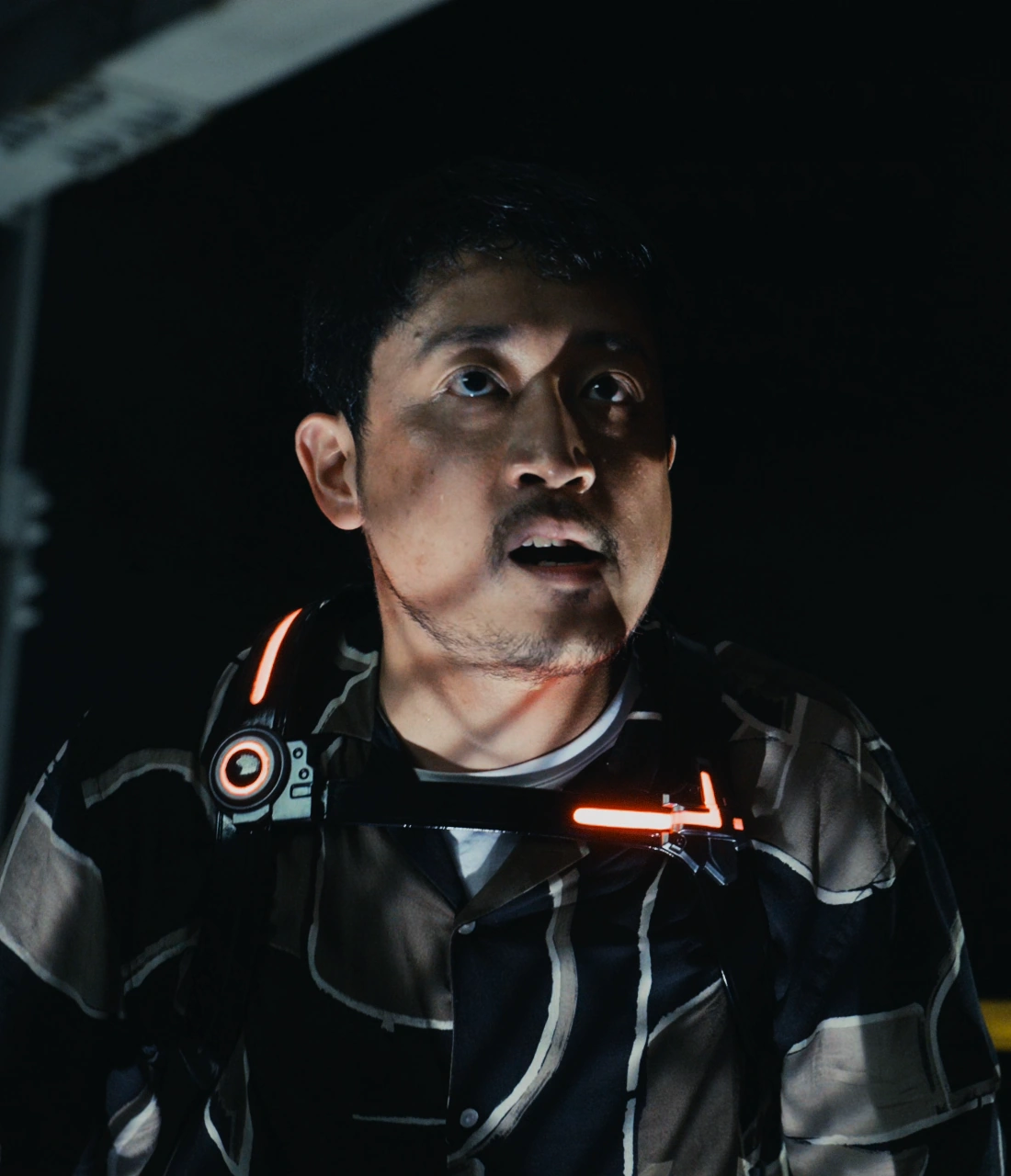 A screenshot of Yuji from Season 2, a man with short black hair and a blue and gray patterned shirt