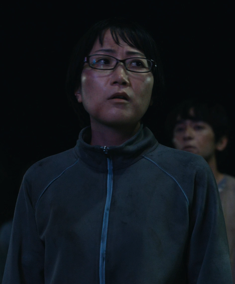 A screenshot of Kaede from Season 2, a woman with short hair and glasses
