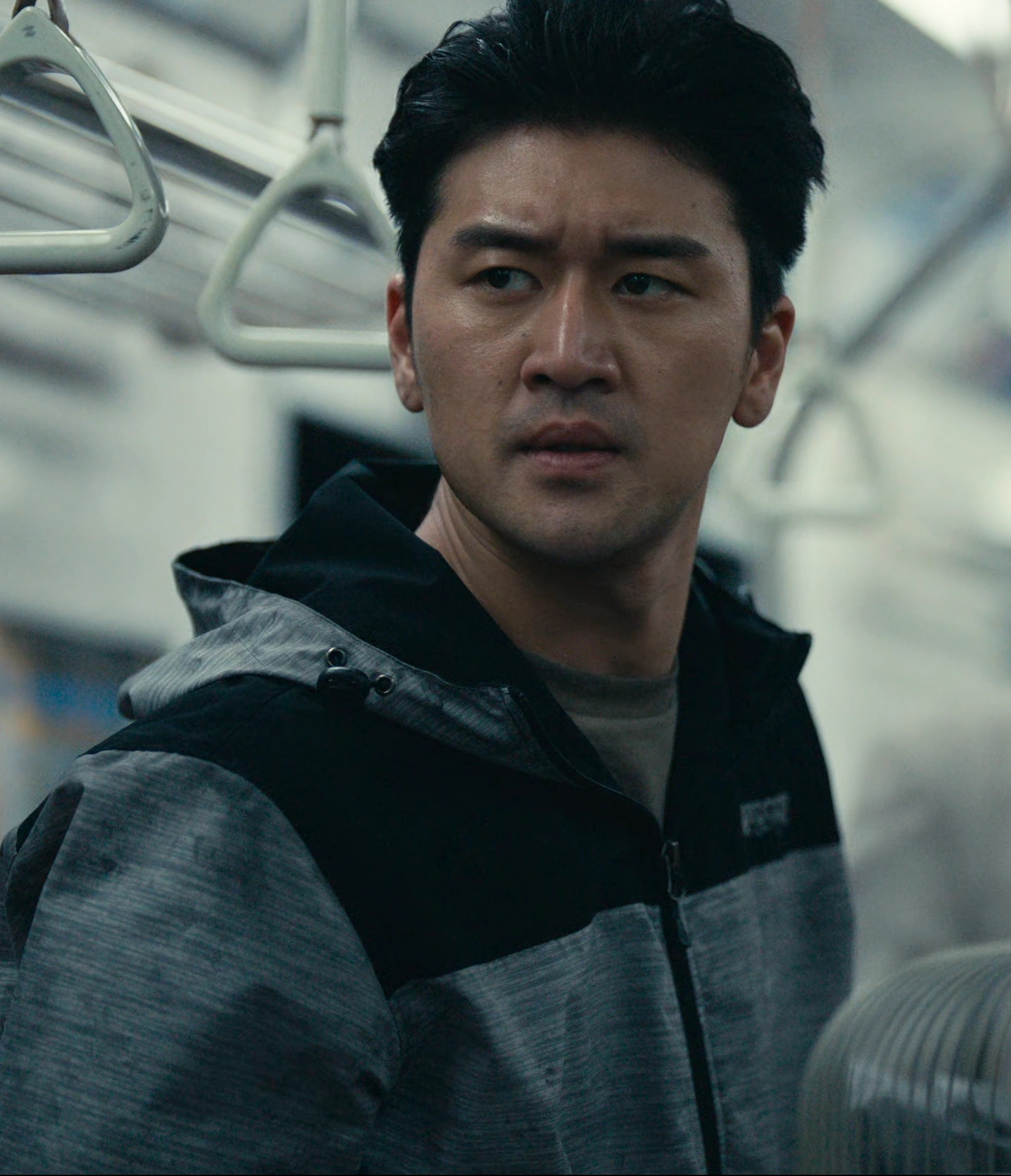 A screenshot of Sohta Itsuki from Season 3, a tall man in a gray and black hoodie, looking determined