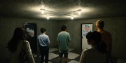 Arisu and the others standing in the first room in the GM Building that they need to escape