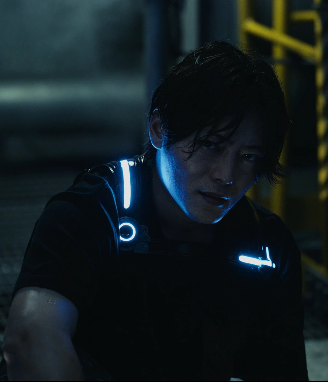 A screenshot of Kazuki from Season 2, a man wearing a black shirt with the word "Panic" where a pocket would be