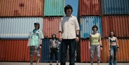 AIB Season 2 Photo 21.jpg (1.61 MB) Arisu, Usagi, Kuina, Tatta, Niragi looking around in shock, multiple colored shipping containers behind them
