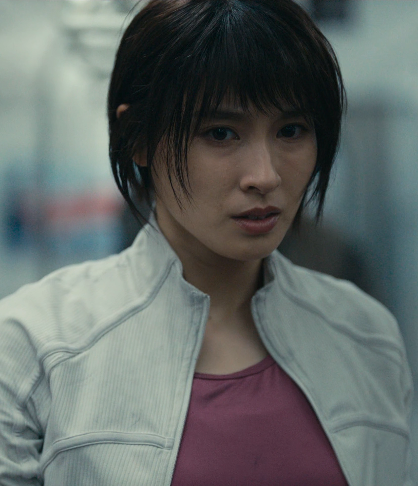 A screenshot of Yuzuha Usagi from Season 3, a young woman with short dark hair on a train with a worried and defeated expression