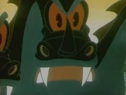 Hummingbird perched on edge of tiny nest places food into mouth of one of two chicks