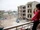 A Syrian girl waves from the balcony of an unfinished apartment block in northern Lebanon (11173940763).jpg