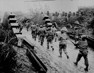 Members of an American black regiment make their way down a road in France.