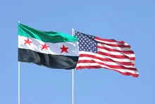 Bandera siria junto a bandera estadounidense