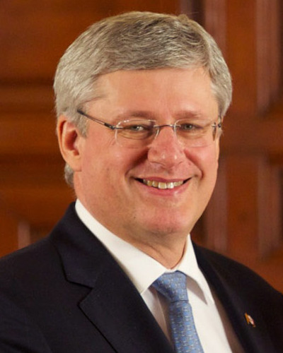 Canadian Prime Minister Stephen Harper autographs a fan's jersey