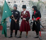 Circassian men in traditional dress, waving the Circassian and republican flag.