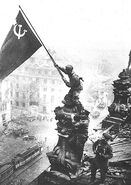 Red Army Sergeant Meliton Kantaria raises the Soviet banner of victory over a near demolished Reichstag at the end of the bloody Battle of Berlin, 1943.