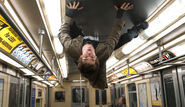 Peter Parker, sticking to the ceiling of a subway train interior.