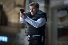 Captain Stacy aims a gun