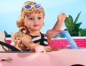 The doll with matching Barbie doll in the pink American Girl RC Sports Car.