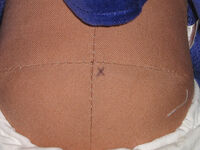 An X on a doll's bottom, indicating purchase from the sale.
