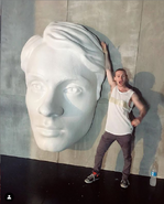 Bruce Langley posing near one of the giant Technical Boy's faces in the CEO headquarters