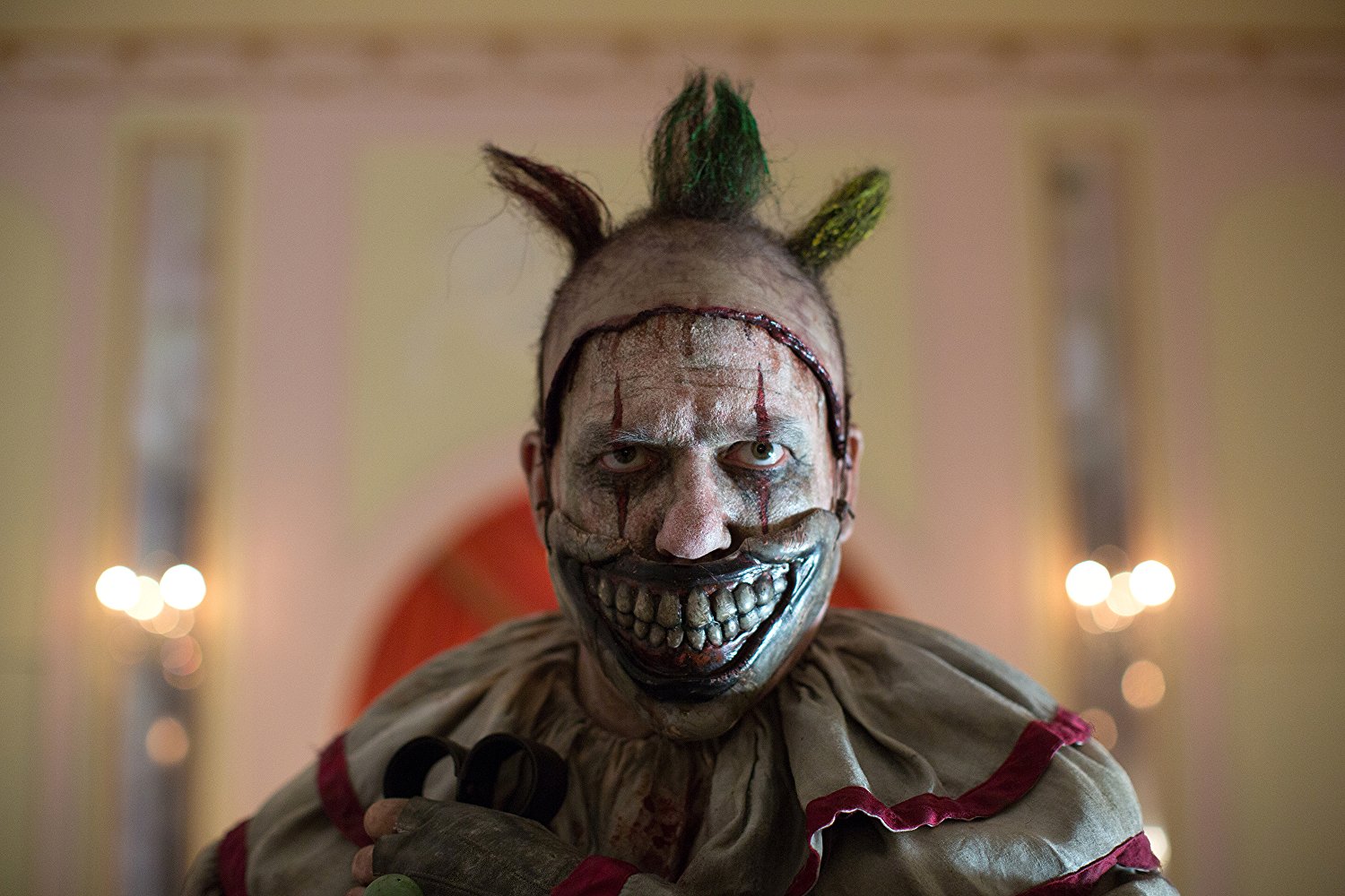 Halloween Makeup Like Pennywise. Street performer clown with a white face.  The look of a man in the guise of IT on a costume cosplay show. Close-up.  Stock Photo