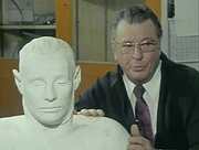Photograph of Mr. Paul Lawson with the plaster bust that he created taken in his office at Adelaide Museum.