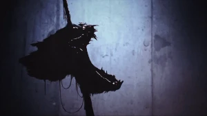 A Huggy Wuggy head stuck to a spike dripping blood, their mouth open and lifeless.