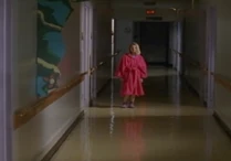 Down the hall a young girl appears