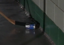 Testing it on his way out, he shoots a pop can with a perfect slap shot