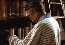 Then he puts on his reading glasses to help him find the books