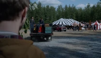 Deep in the woods, he can see that a carnival is being set up