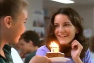 The girl offers her a brownie to welcome her to their school