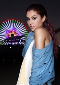 Ariana posing with a ferris wheel in the background