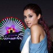 Ariana posing with a ferris wheel in the background