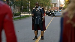 O Monitor sendo confrontado pelos heróis da Terra-1, Supergirl e o Flash da Terra-90.