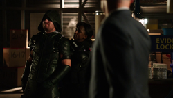 Lance watches as Liza Warner holds the Green Arrow hostage