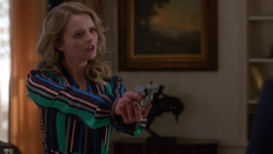 Eve holds Lena at gunpoint