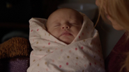 Mia as an infant in the original timeline