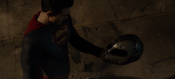 Superman segurando o capacete do exotraje de Luthor