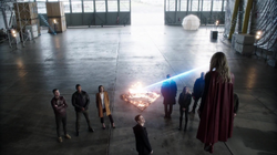 Supergirl demonstrando seus poderes para os heróis da Terra-1