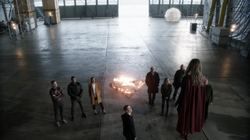 Supergirl demonstrando seus poderes para os heróis da Terra-1