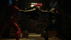 Batwoman subduing the Flash and Green Arrow