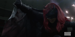 Batwoman covers herself from Crow bullets