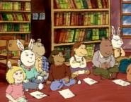 With the other kids (most likely her friends) listening to Jack Prelutsky speak.