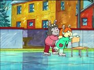 Wearing a green sweater with earmuffs.