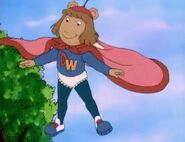 D.W. is wearing her blankie as a superhero cape in Arthur's fantasy in "D.W. the Copycat".