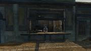 Ezio standing by a book shop
