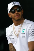 A black man in his early thirties with short facial hair smiling while wearing a hat.