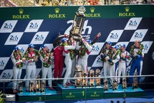 , , and  hoist the winners trophy during the podium ceremony