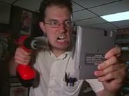 The Nerd about to drill the Dick Tracy NES cartridge.