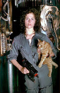 Ripley (who like Parker never uses the weapon in the final film, but was going to in a scrapped ending to Alien) carrying Jones and armed with a laser pistol.