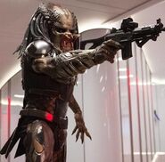 Fugitive Predator holding a gun.