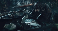 The Upgrade Predator throws the Fugitive Predator onto a car before killing him.